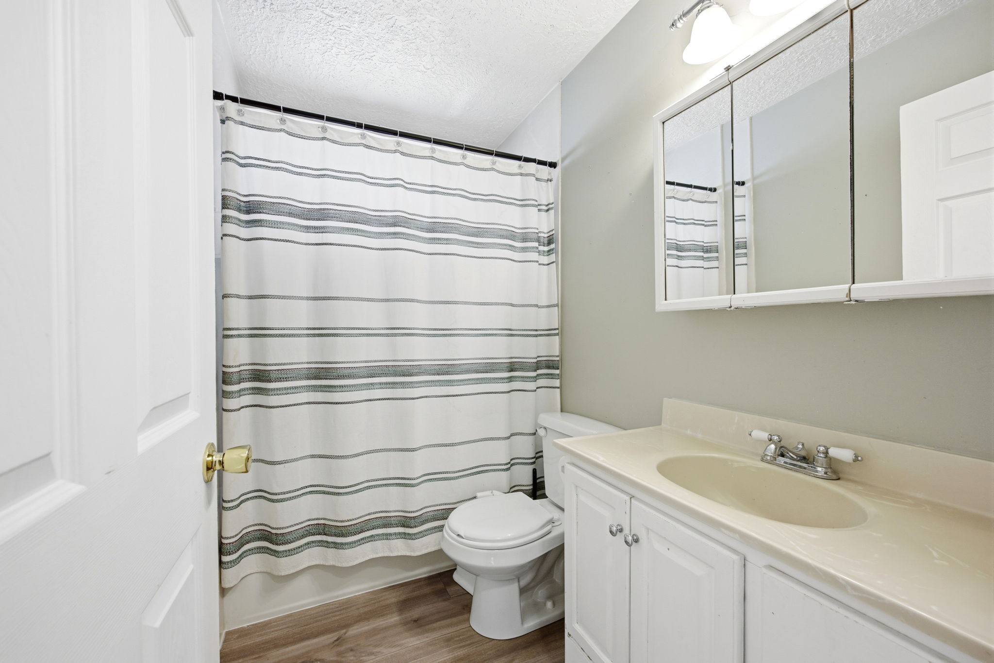 Bathroom featuring a vanity with integrated sink, white cabinetry, and a wall-mounted medicine cabinet