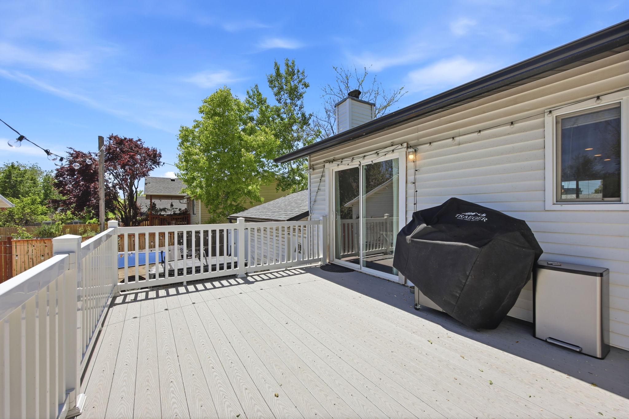Spacious outdoor deck featuring light-toned composite decking with white railing