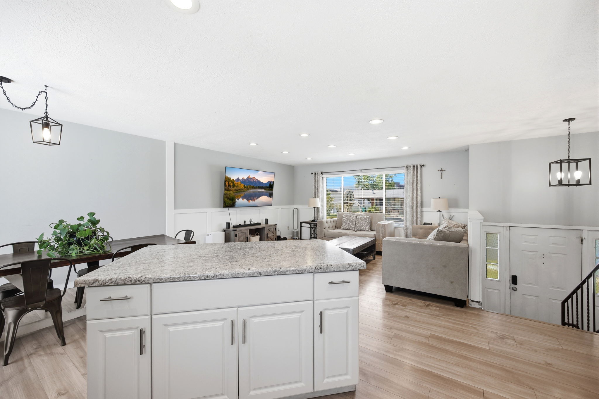 Kitchen island with a light-colored granite countertop and white cabinetry