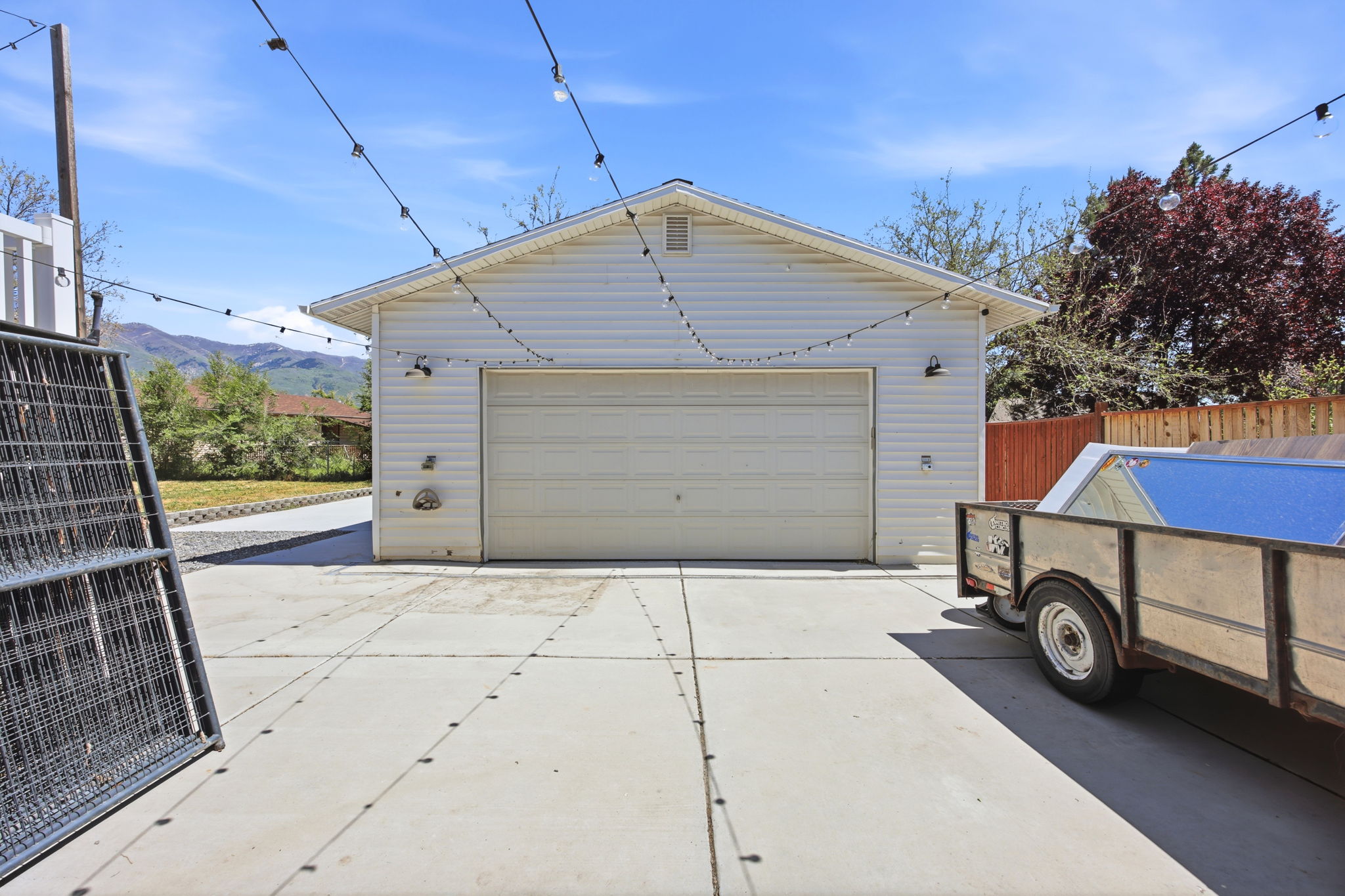 Detached garage structure featuring white siding and a single garage door