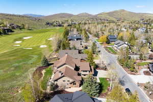 Residential properties alongside a golf course, surrounded by mountainous terrain and mature trees