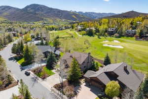 Expansive mountain landscape featuring a golf course, mature trees, and residential properties