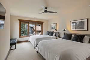 Carpeted room featuring two upholstered bed frames with recessed lighting and wall art