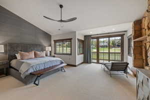 Spacious room featuring vaulted ceilings, a textured accent wall, and a stone fireplace