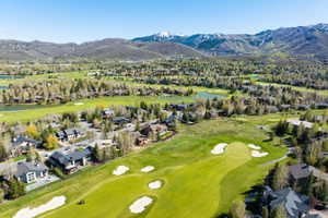 Expansive golf course property featuring manicured greens, sand traps, and surrounding residences