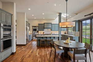 Open-concept kitchen and dining area featuring rich wood-finish flooring