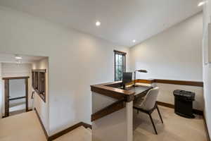 Upper-level landing featuring a built-in desk area with a framed window, recessed lighting, and rich wood trim