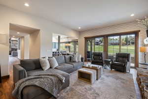 Living area with wood-framed sliding glass doors, recessed lighting, and a stone-clad fireplace