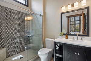 Glass-enclosed shower with mosaic tile surround and built-in bench