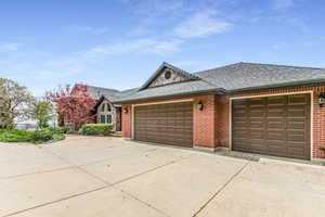 Brick exterior with a stone accent gable, featuring a multi-car garage with panel garage doors