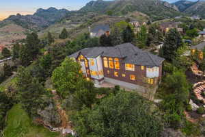 Hillside residence featuring a multi-level design, extensive fenestration, a brick exterior, and a prominent bay window
