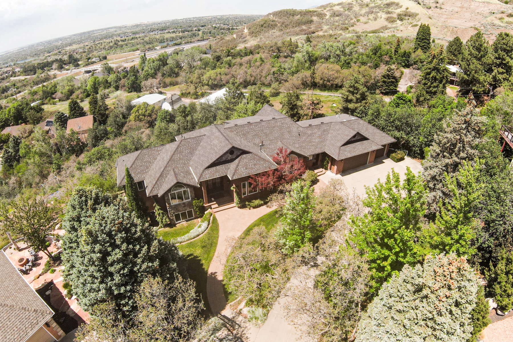 Expansive property featuring a multi-gabled roofline, mature landscaping, an attached garage, and a paved driveway