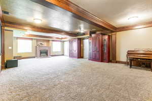 Spacious living area featuring a brick fireplace, multiple windows with blinds, recessed lighting, and a ceiling fan