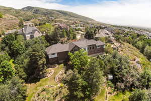Hillside property featuring a multi-story residence with a brown brick facade and white trim