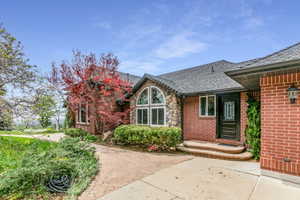 Brick and stone exterior with a dark asphalt shingle roof