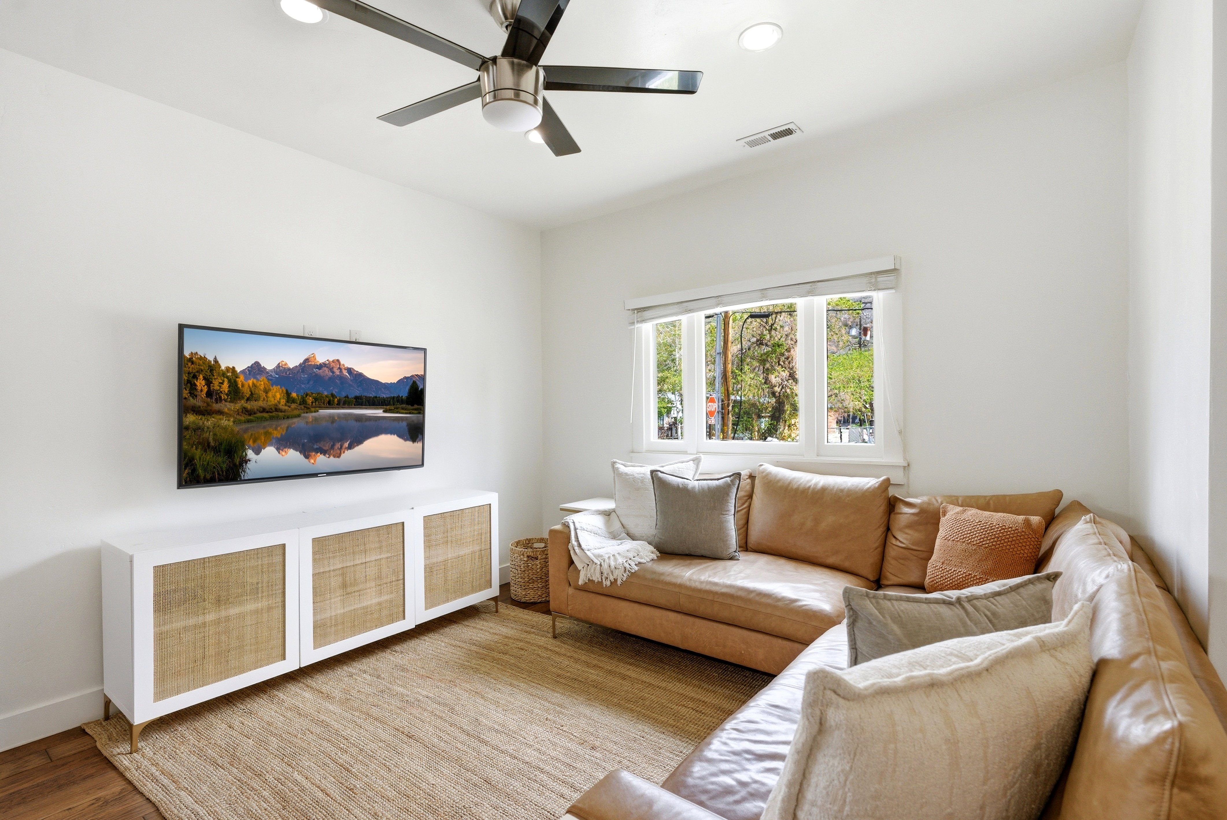 Living area featuring a ceiling fan, recessed lighting, and white walls