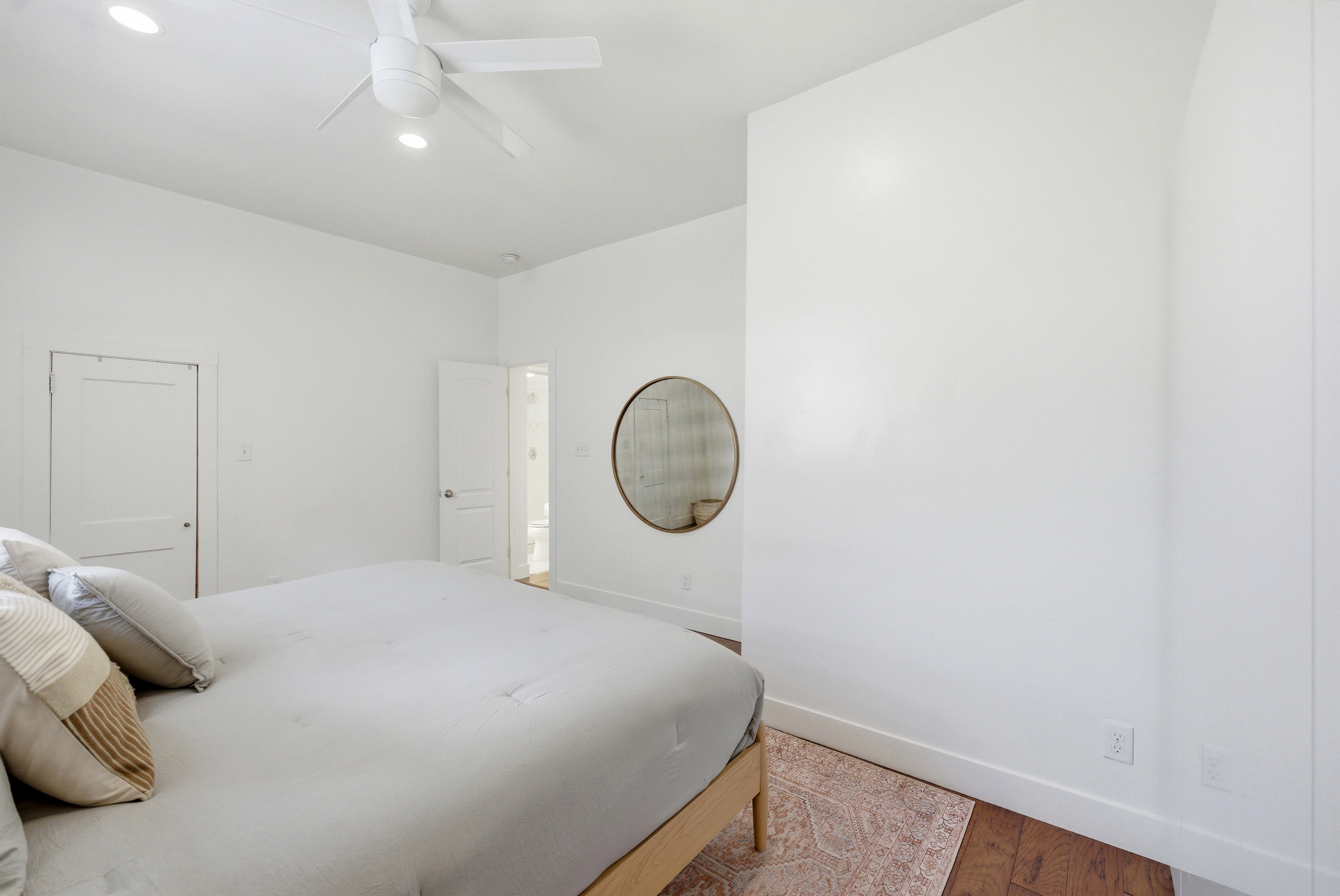Spacious interior featuring a contemporary ceiling fan, recessed lighting, and rich wood-finish flooring