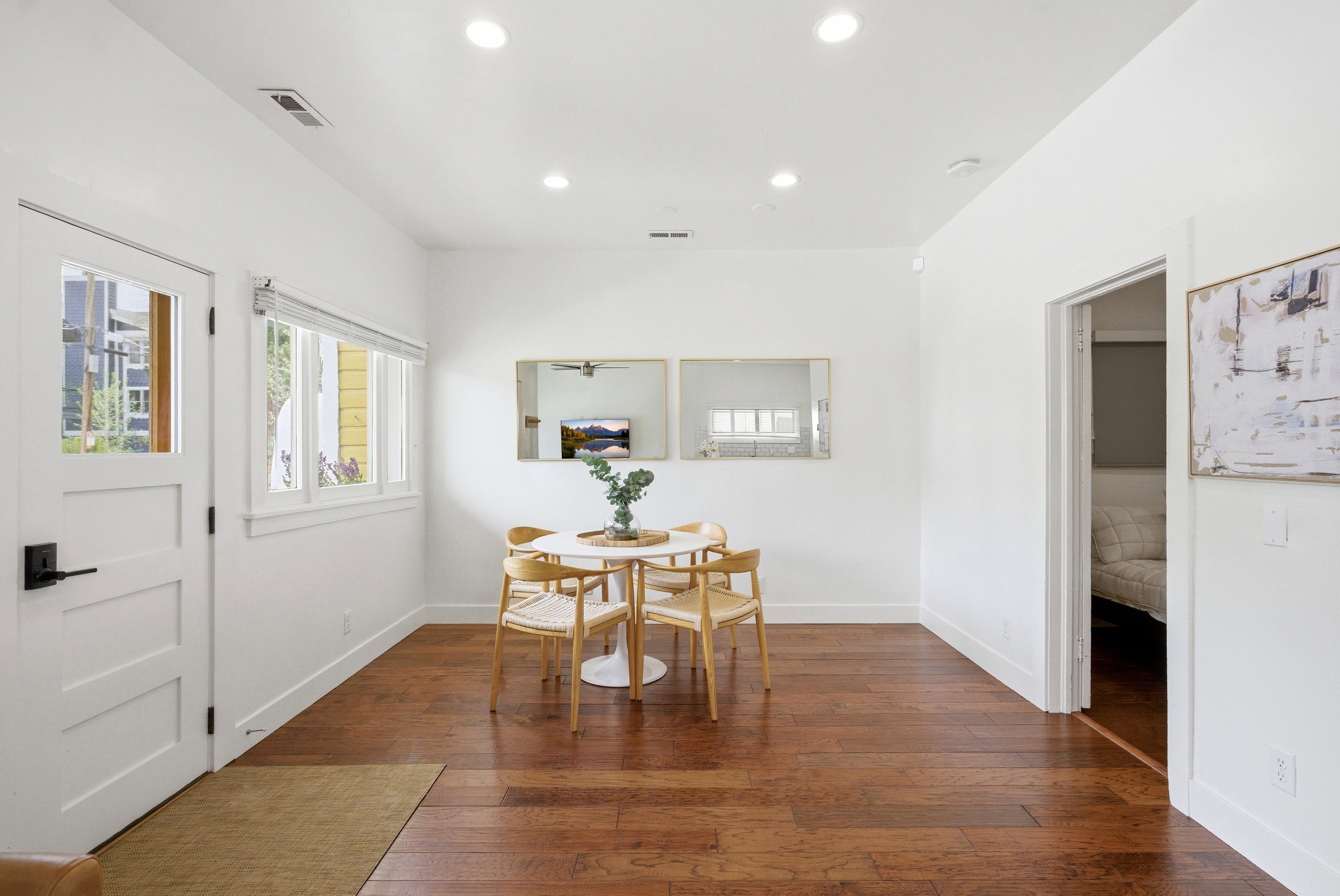 Hardwood-finish flooring throughout, featuring a white paneled door with glass inserts and dark hardware
