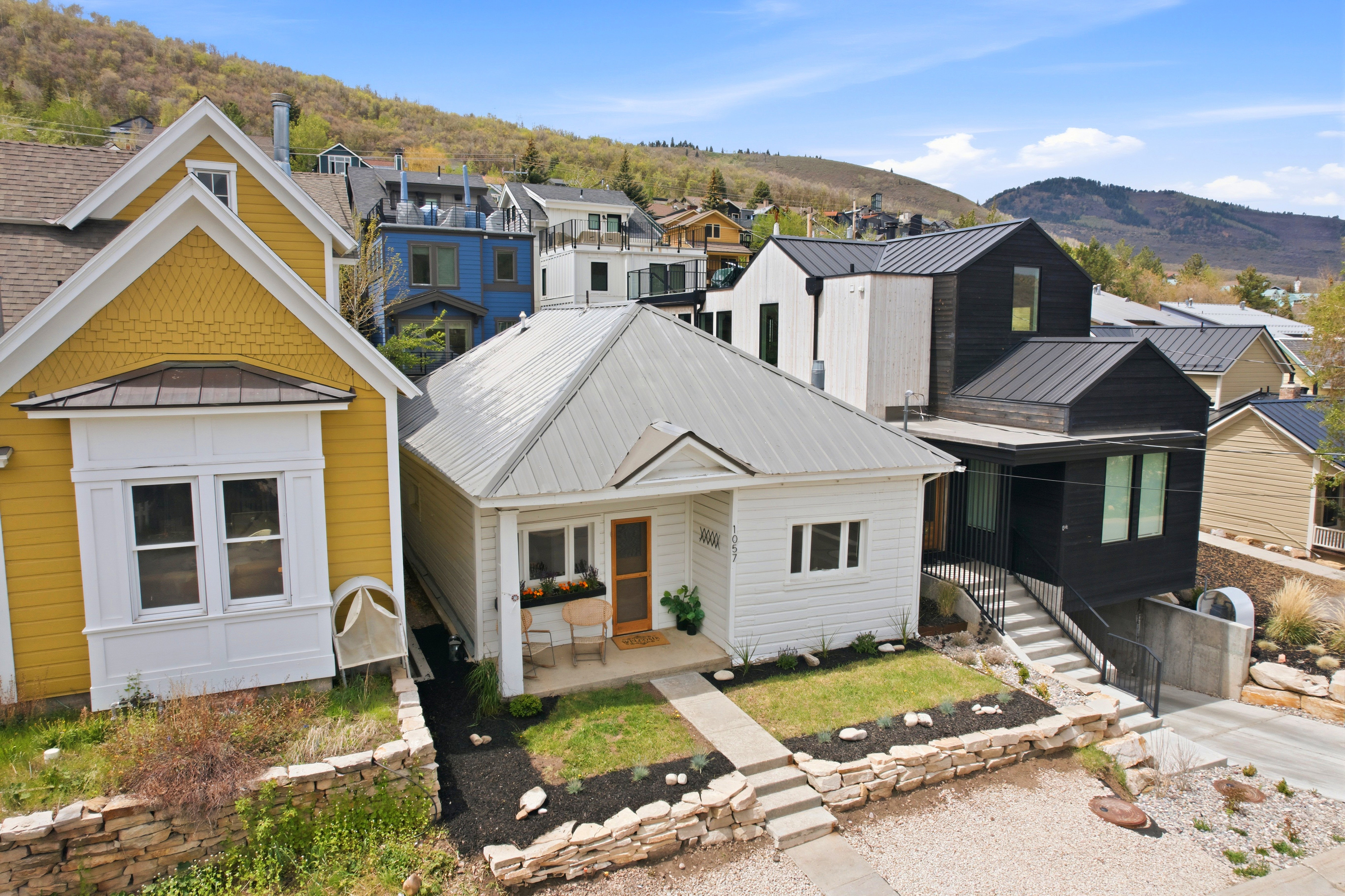 White siding exterior with a metal roof and a covered porch