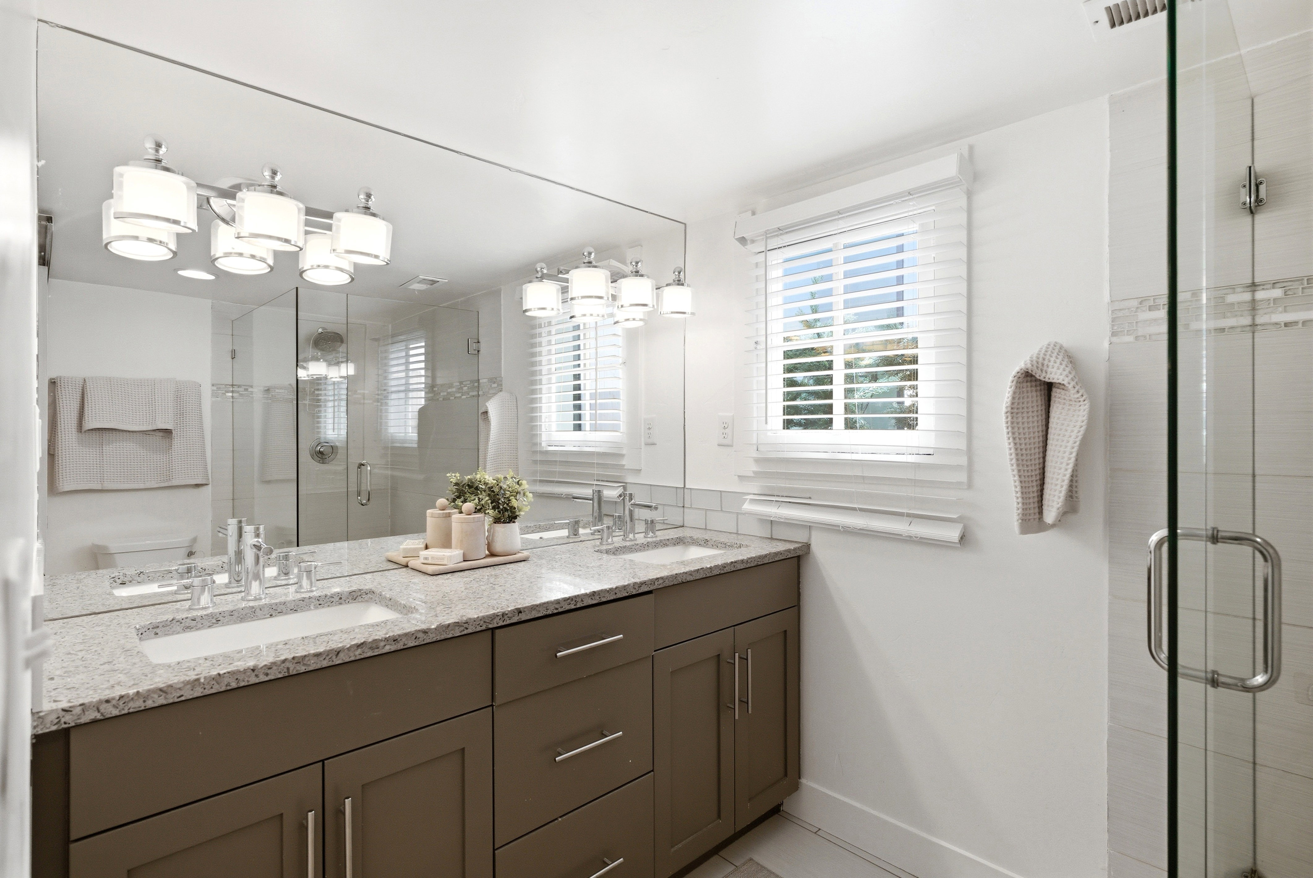Double vanity with a light speckled countertop and undermount sinks