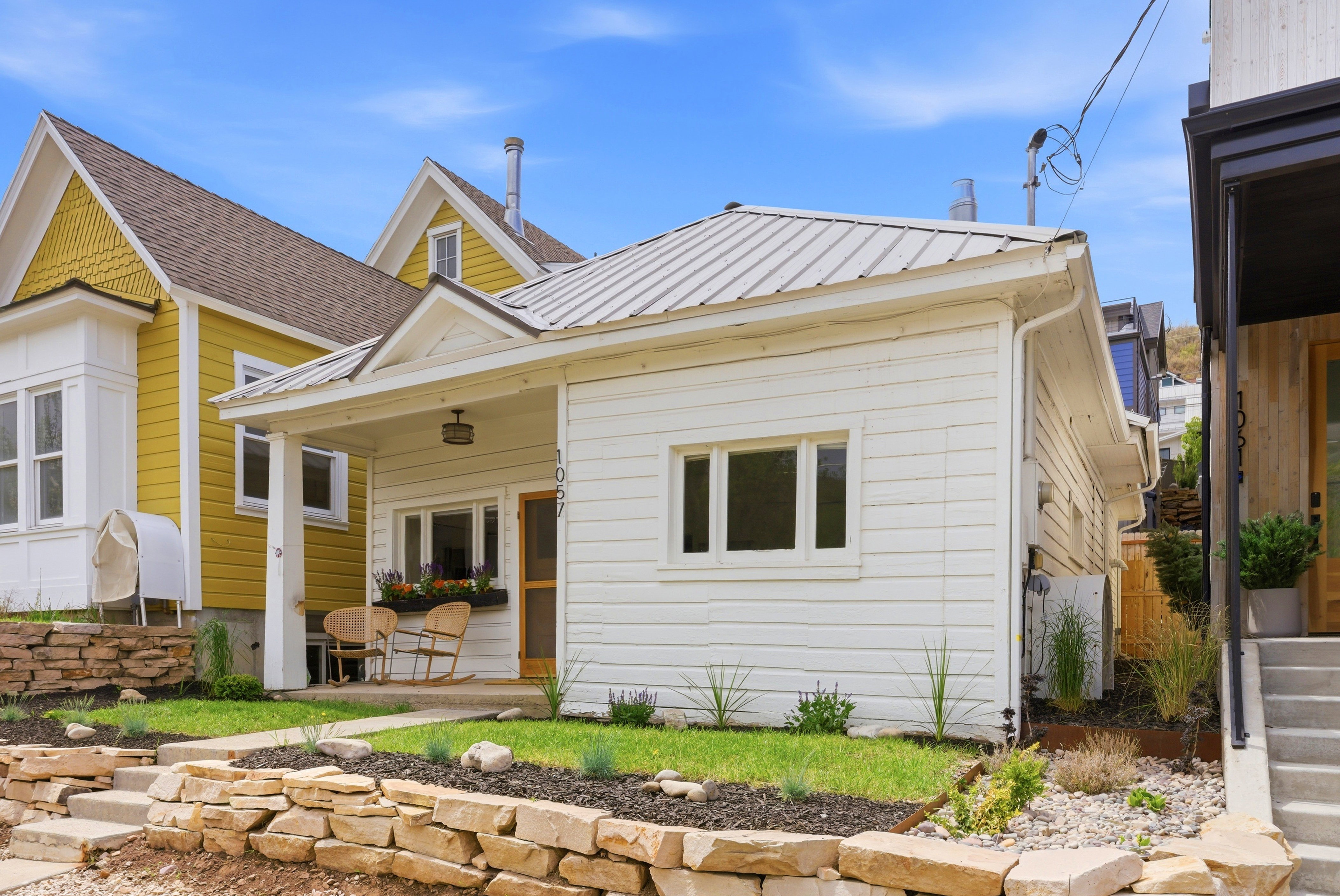 White clapboard siding exterior with a metal roof