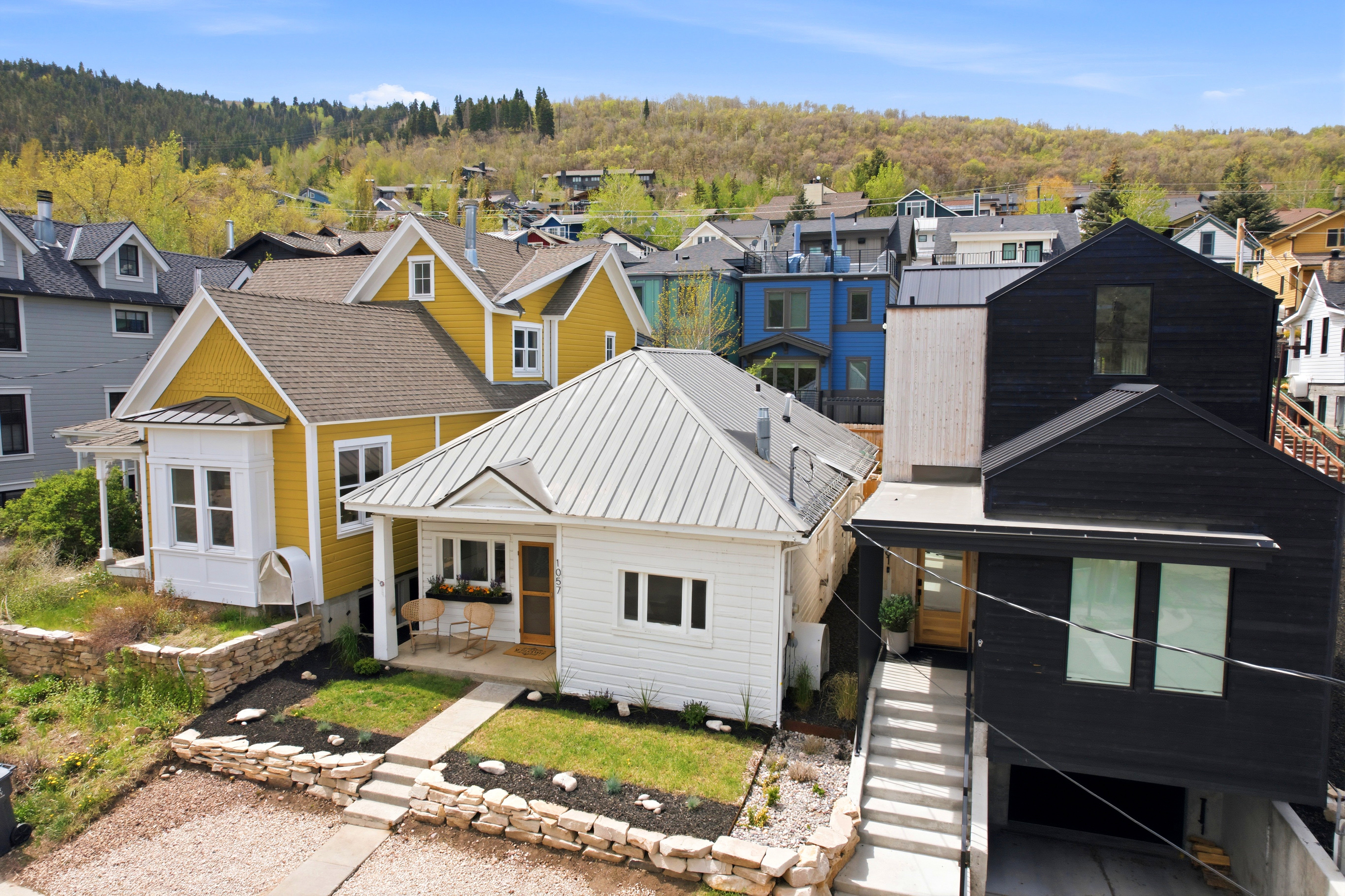 Contemporary residence featuring a black exterior, light wood siding accents, and a metal roof
