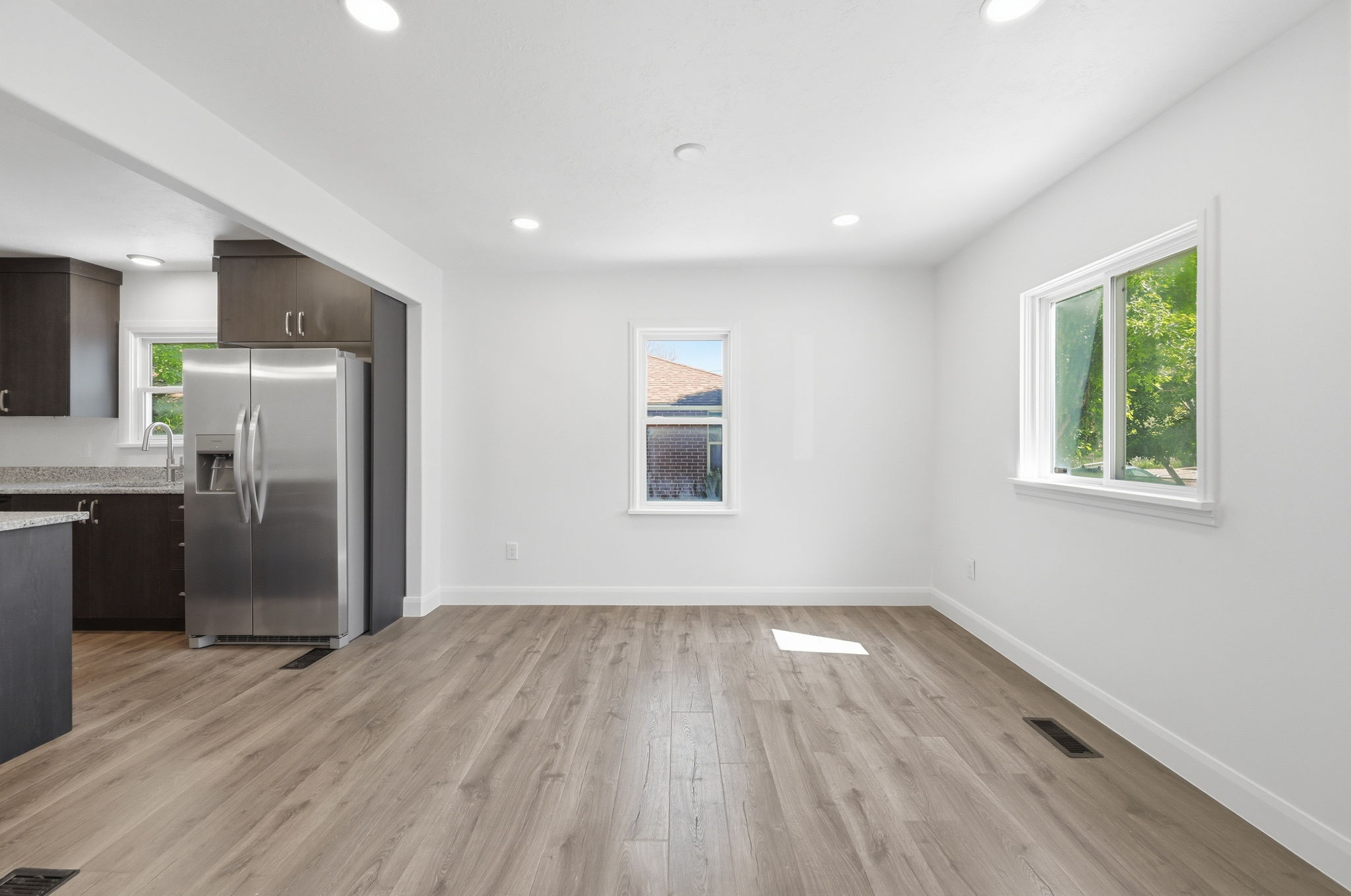 Open concept living space featuring wood-finish flooring and recessed lighting