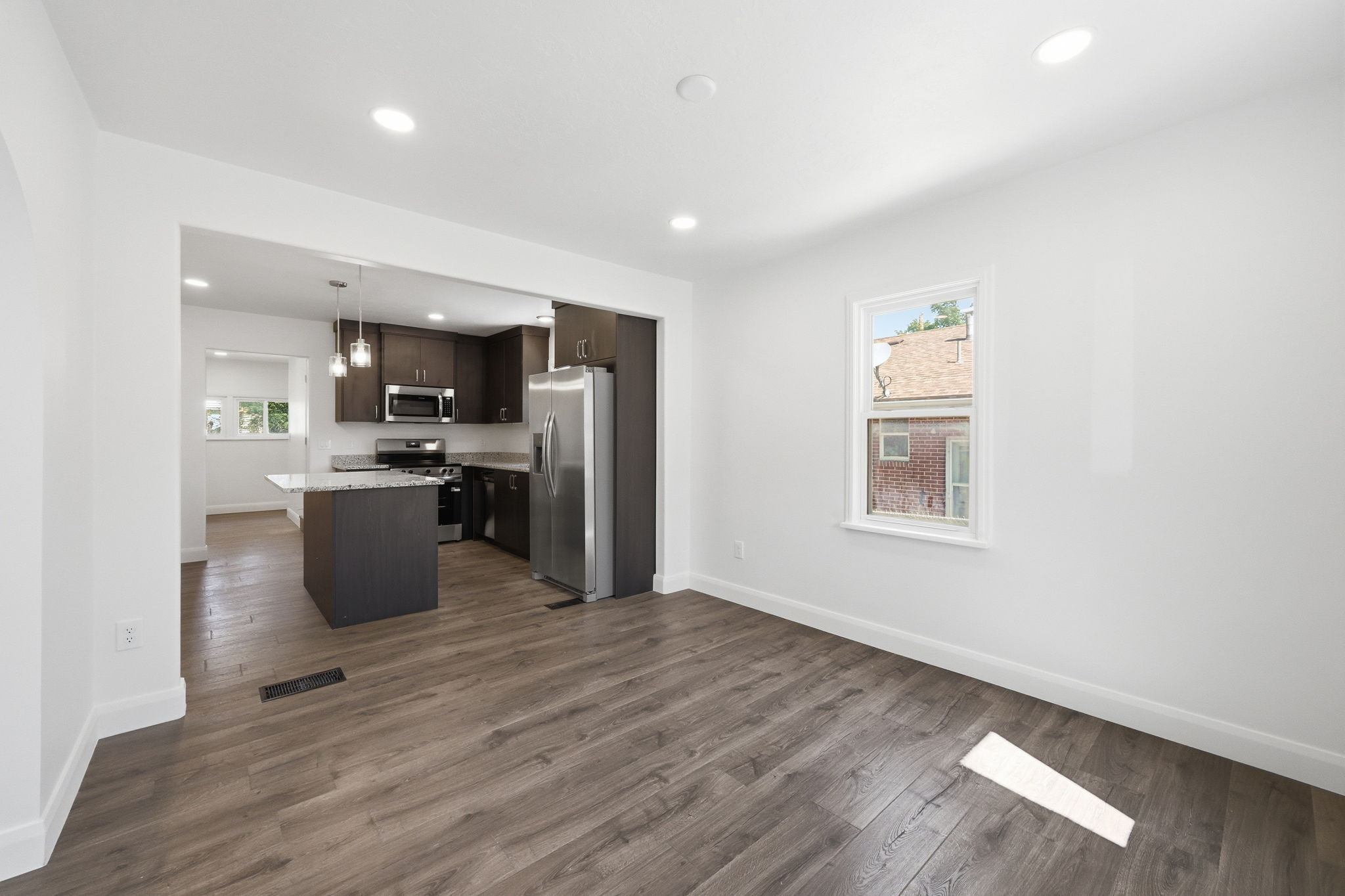 Open concept living space featuring wood-finish flooring and recessed lighting