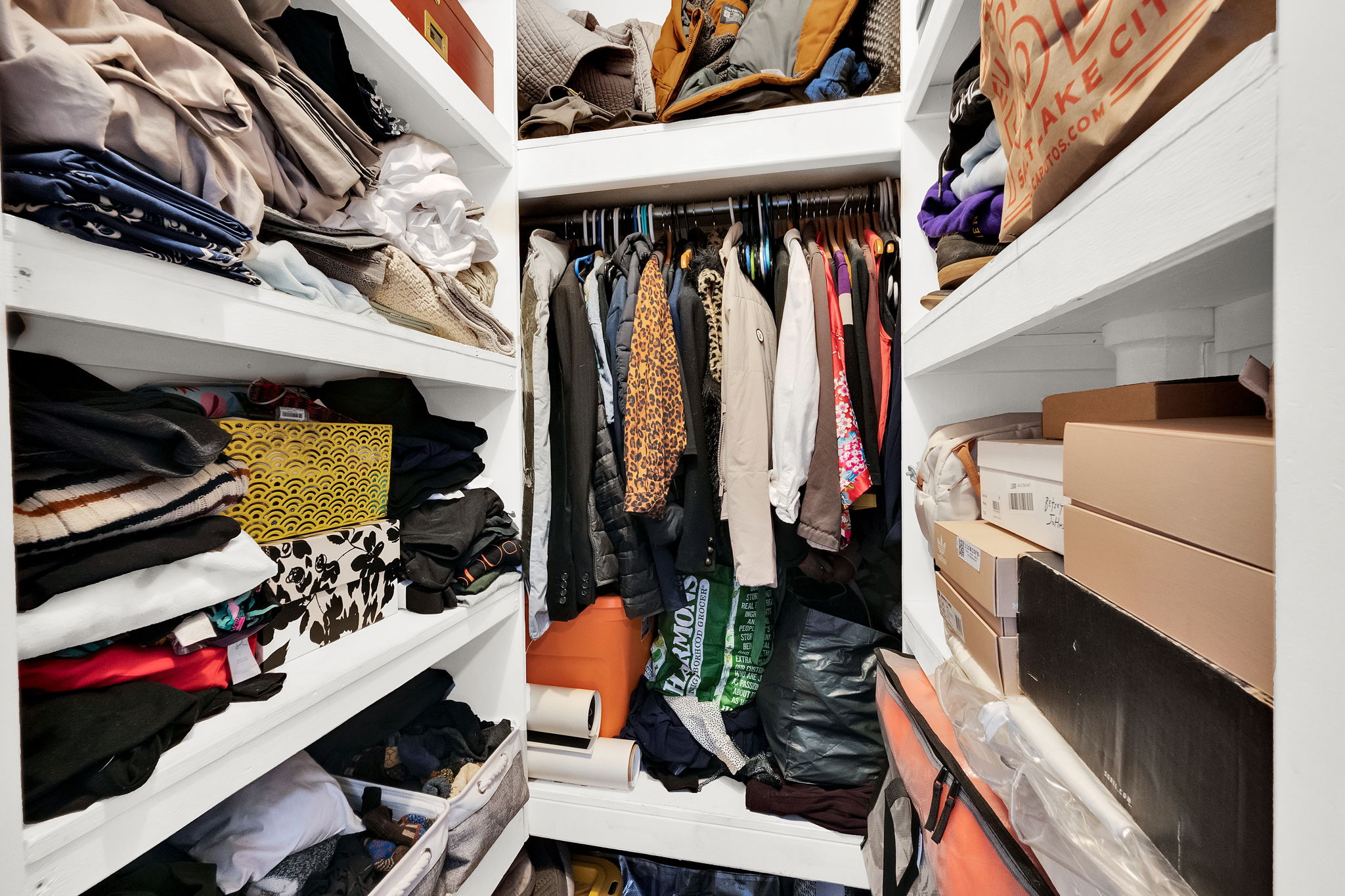 Built-in closet system featuring white shelving and hanging rods