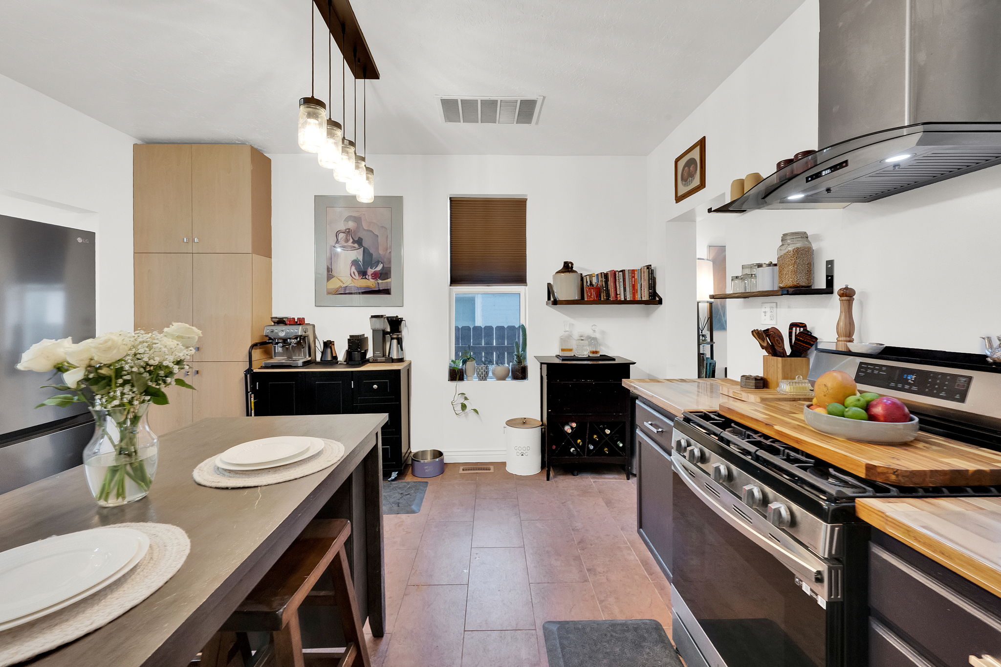Contemporary kitchen featuring wood-finish flooring, light wood-tone cabinetry, and stainless steel appliances