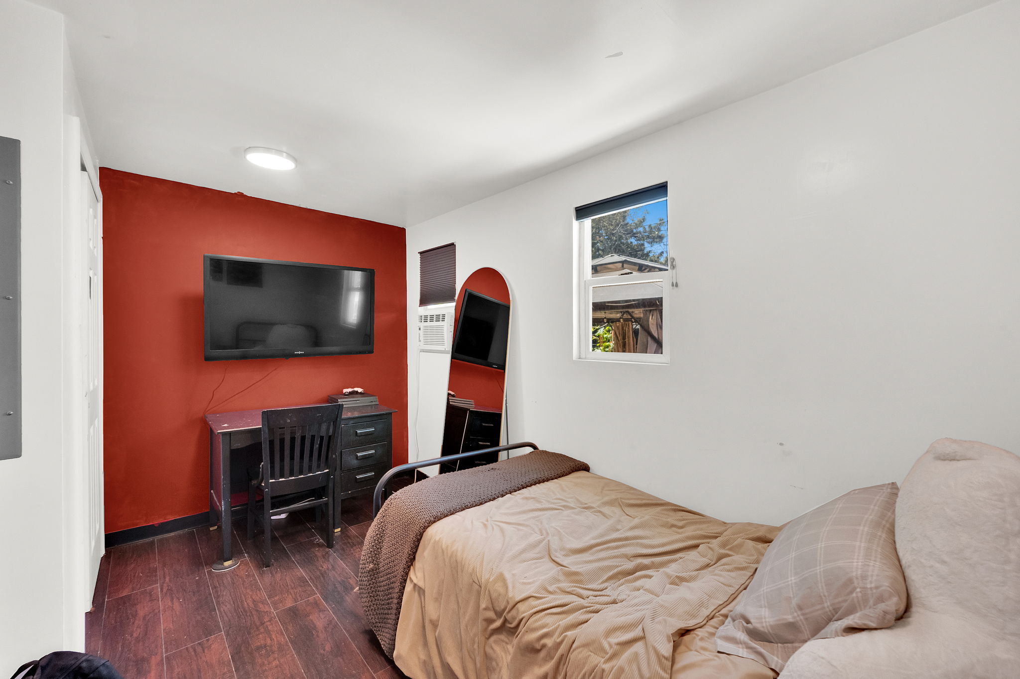 Interior space featuring wood-finish flooring, a white ceiling with a flush-mount light fixture, and a window with natural light