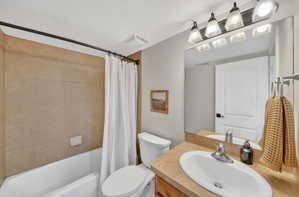Bathroom featuring a vanity with an integrated sink, a rectangular mirror, and a four-light fixture