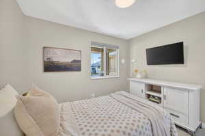 Neutral tone bedroom featuring a single window with blinds