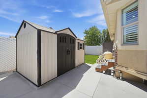 Outdoor storage shed with dual barn-style doors and shingled roof