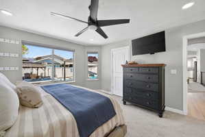 Bedroom featuring a large window, secondary window, ceiling fan, recessed lighting, and carpet flooring