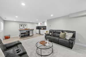 Spacious lower-level area featuring recessed lighting, light-toned carpeting, and wood-finish flooring