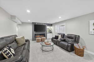 Spacious living area featuring light gray walls and plush carpeting