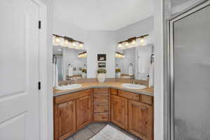 Dual vanity with wood cabinetry and a neutral countertop