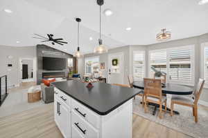 Kitchen island with a dark countertop and white cabinetry featuring dark hardware
