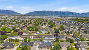 Expansive neighborhood showcasing diverse residential architecture and mature trees, set against a backdrop of distant mountains