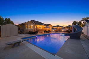 Expansive outdoor area featuring a swimming pool with a diving board and slide, a hot tub, multiple gazebos, and a patio with outdoor dining furniture