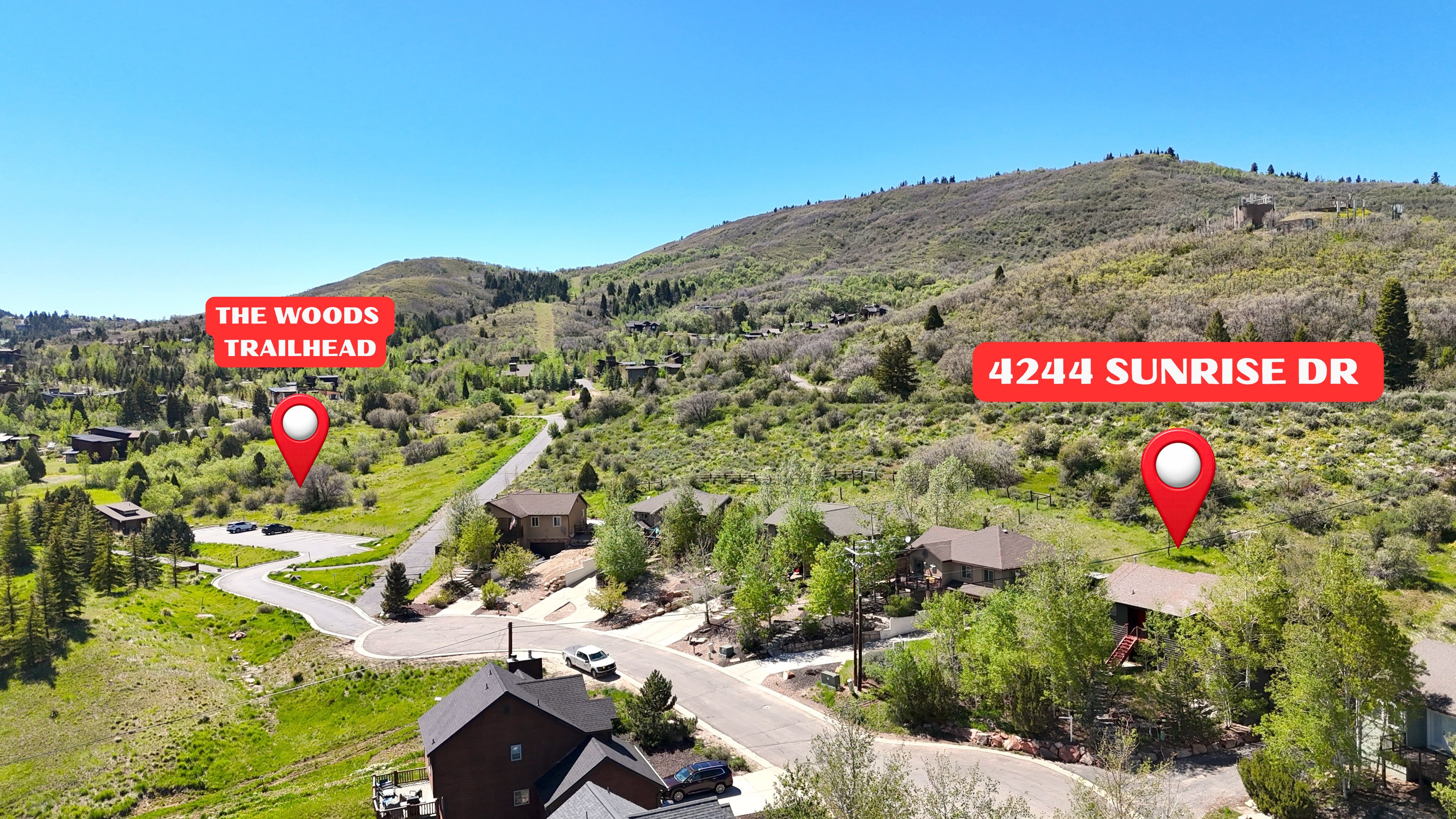 Mountainous terrain with natural landscaping, surrounded by residential properties and paved roads