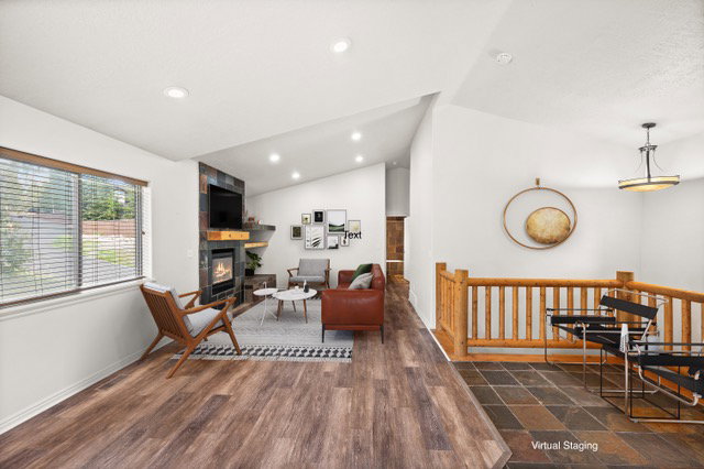Living area with vaulted ceilings, recessed lighting, and wood-finish flooring