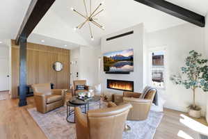 Living area featuring a sleek linear fireplace, wood-finish flooring, and a decorative slatted wood accent wall