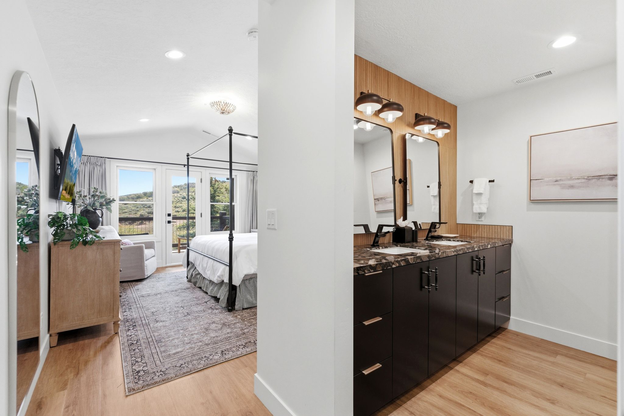 Dual vanity with dark cabinetry, stone countertop, and two framed mirrors