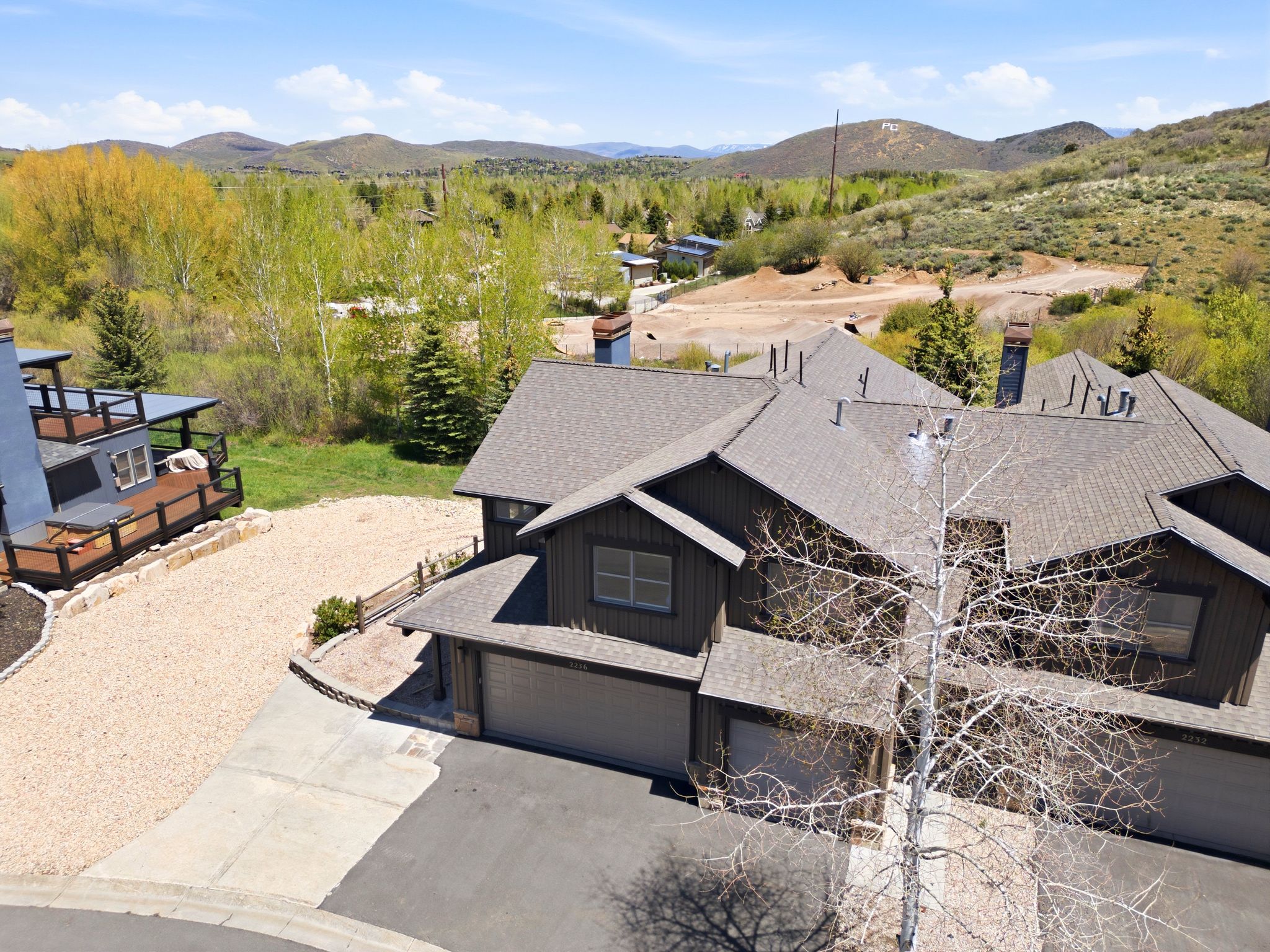 Multi-unit property featuring dark siding and gray shingle roofing
