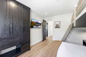 Built-in dark wood cabinetry with silver hardware, light wood-finish flooring, and white walls
