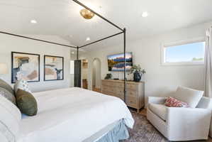 Bright room featuring a four-poster bed frame, recessed lighting, and a decorative ceiling fixture