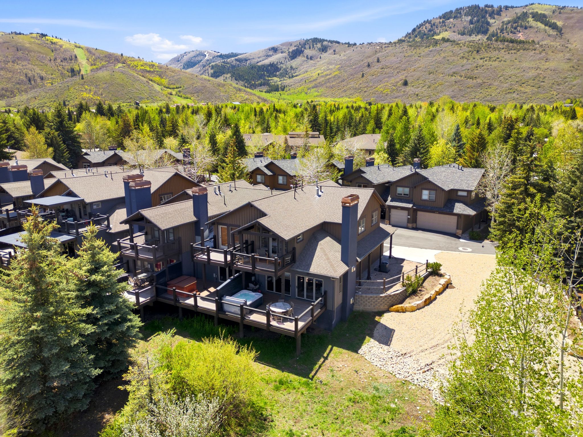 Mountain-style residence featuring multiple balconies, a hot tub, and an expansive deck