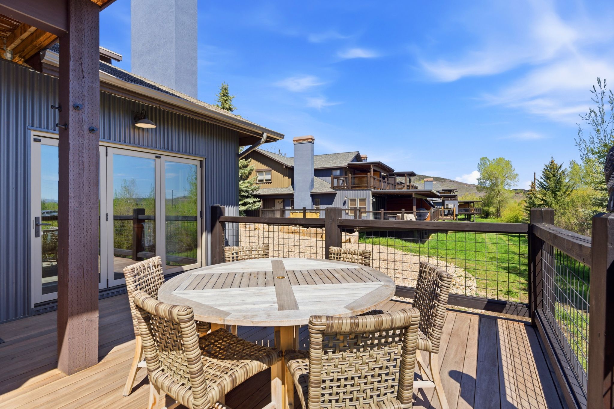 Spacious outdoor deck featuring wood-finish flooring and a rustic wood railing with wire mesh infill